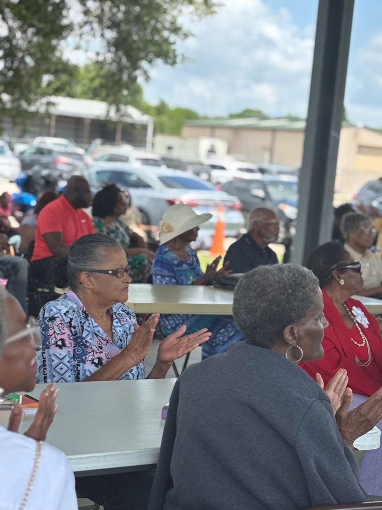 A group of people are sitting at tables applauding.