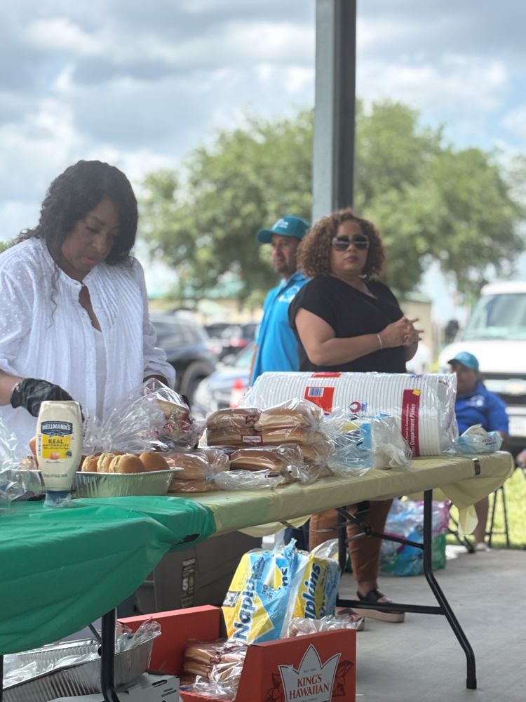 A woman is standing at a table with a bunch of food on it.