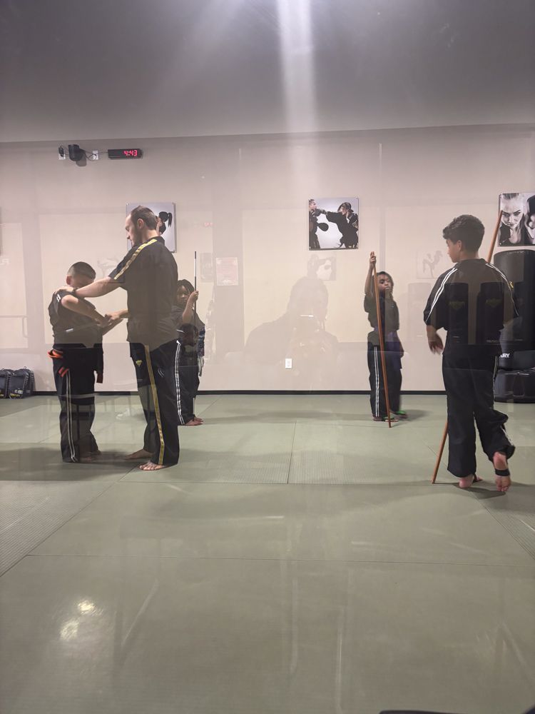 A group of children are practicing martial arts in a gym.