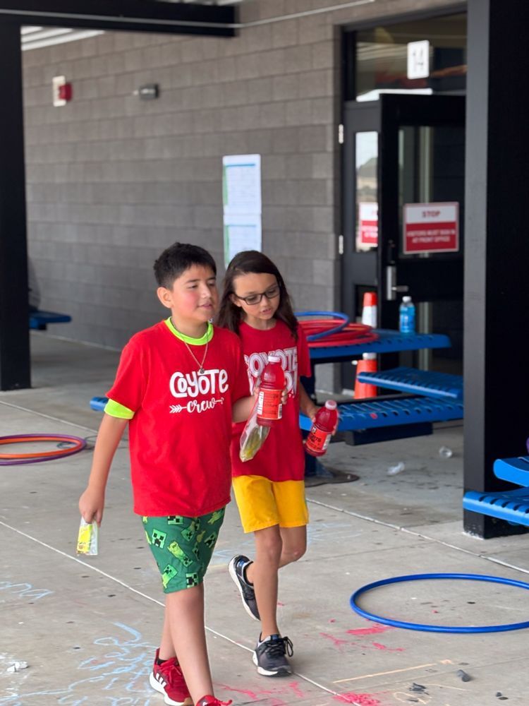 A boy and a girl are walking in front of a building.