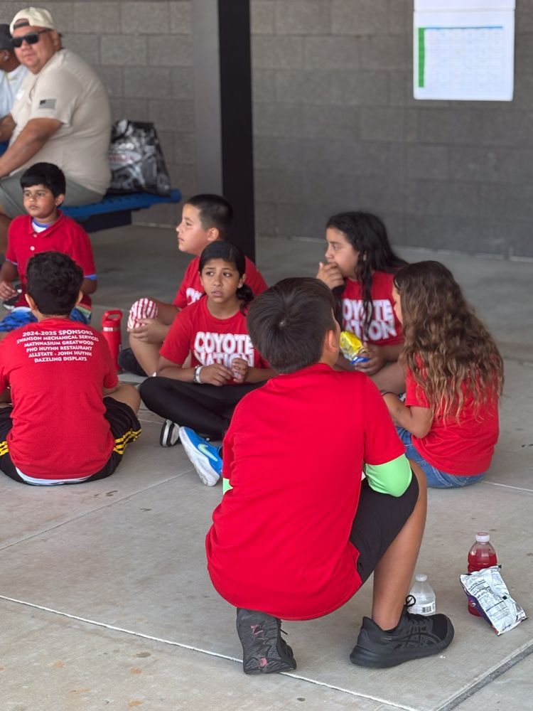 A group of children wearing red shirts with the word coyote on them