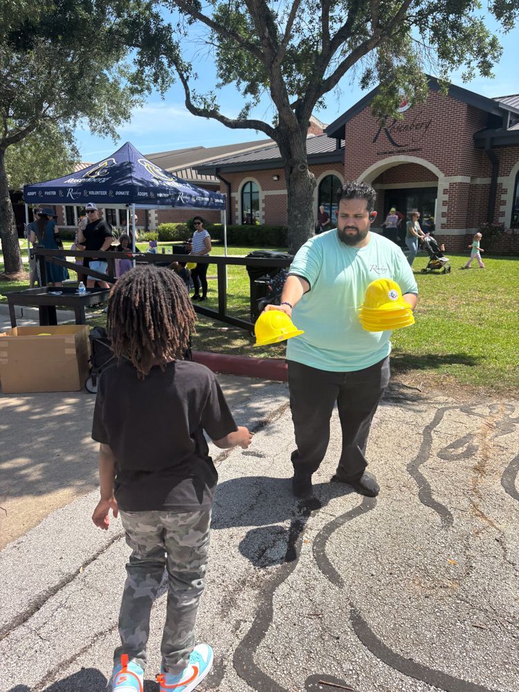 A man is giving a child a yellow hat.