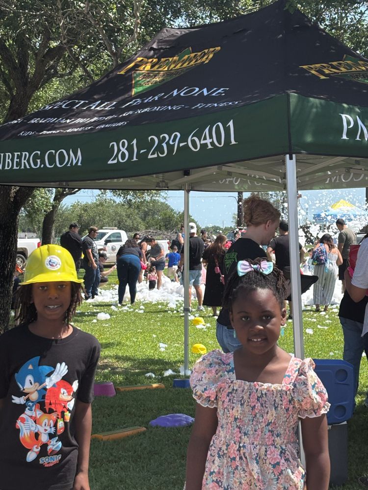 Two children are standing under a tent that says berg.com