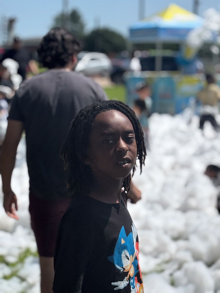 A boy wearing a sonic shirt is standing in a pile of foam