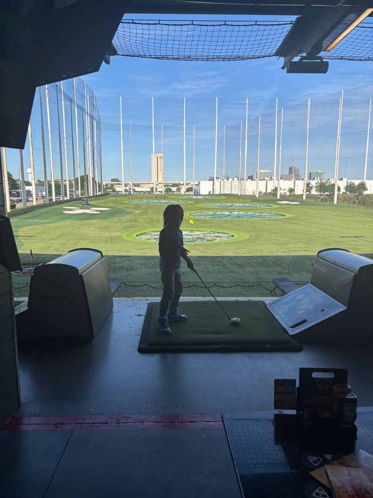 A little boy is playing golf on a golf course.