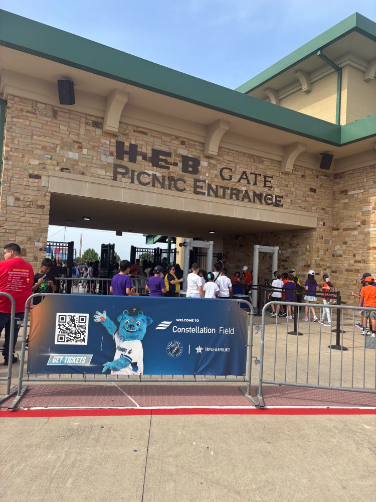 A group of people are standing outside of the heb gate picnic entrance