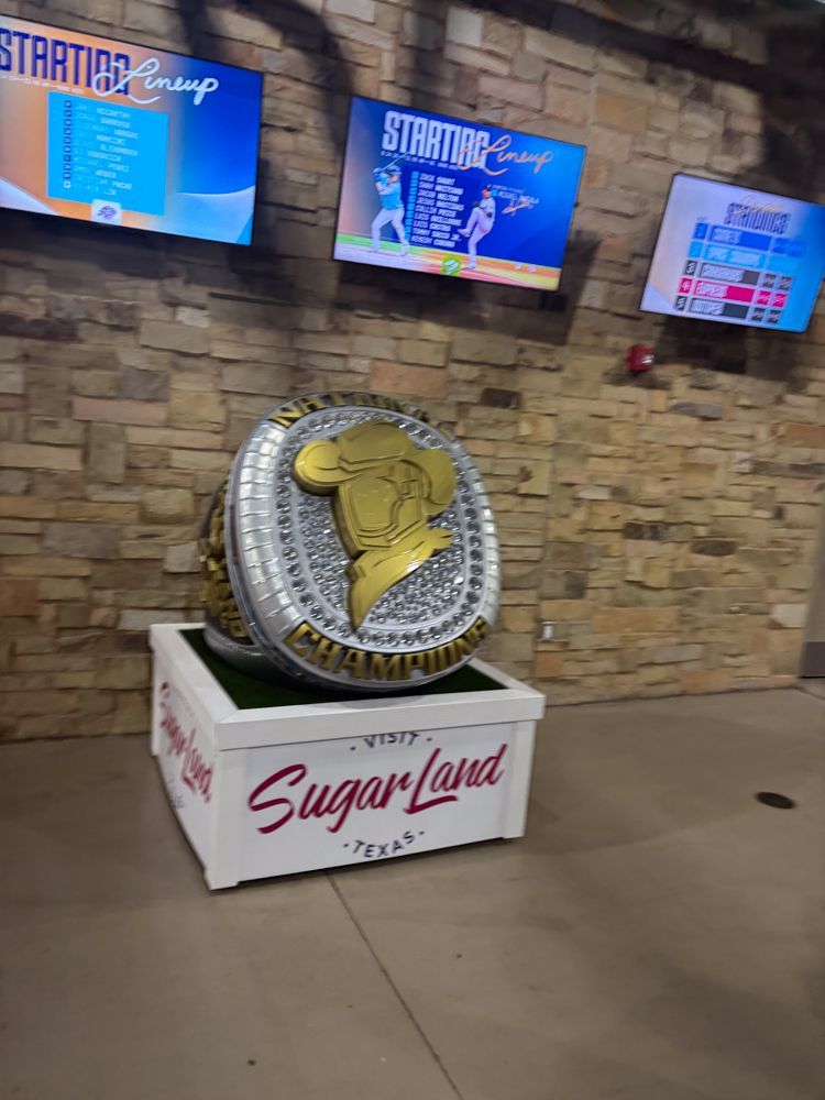 A large ring is sitting on top of a white box in front of a brick wall.