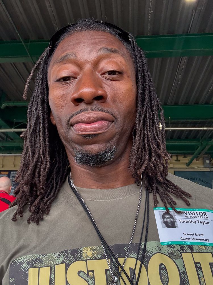 A man with dreadlocks is wearing a just do it shirt