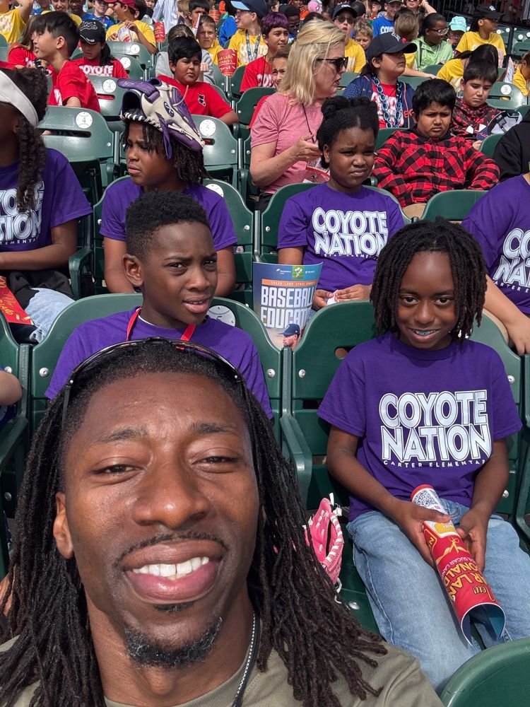 A group of children wearing purple shirts that say coyote nation