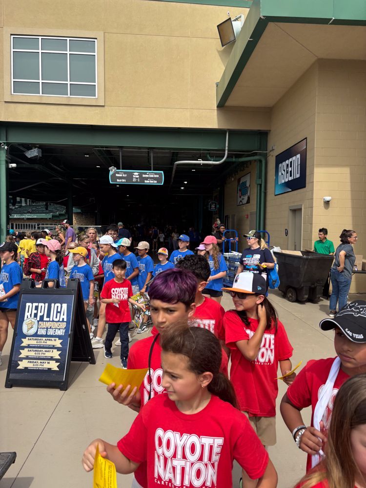 A group of people wearing red shirts that say coyote nation
