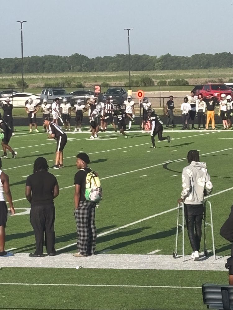 A group of people are standing on a football field