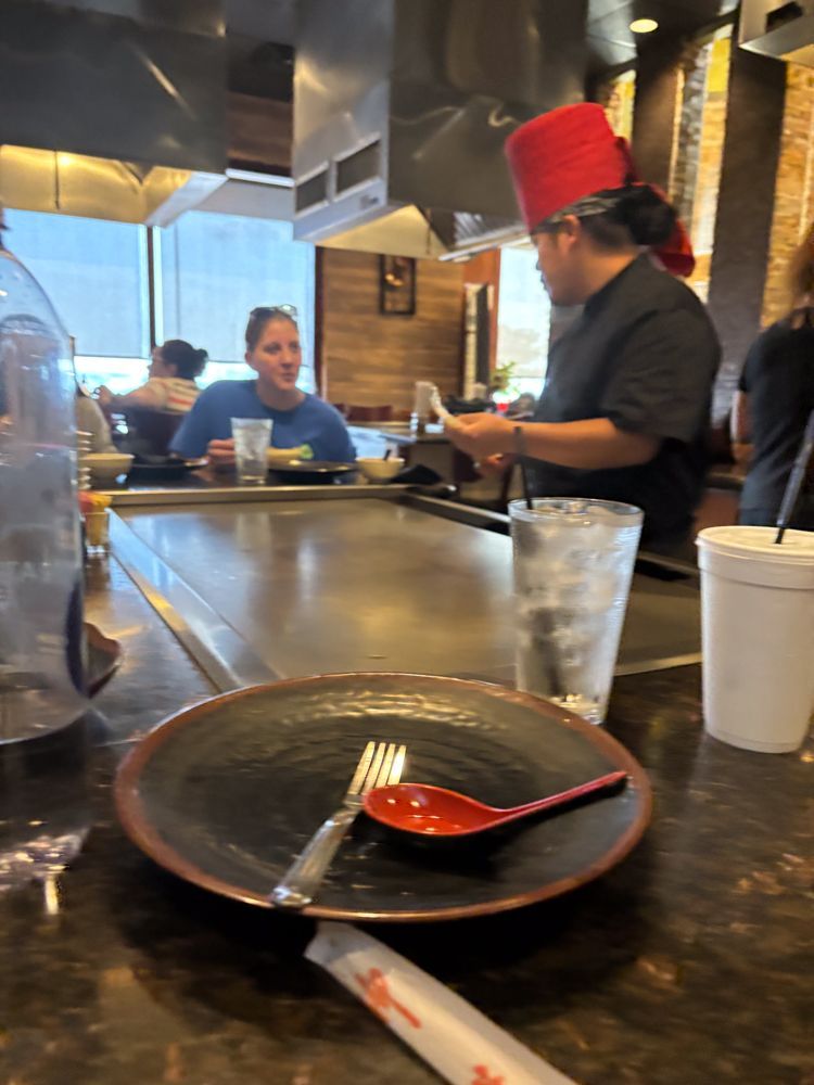A plate with a fork and spoon on it is on a table in a restaurant.