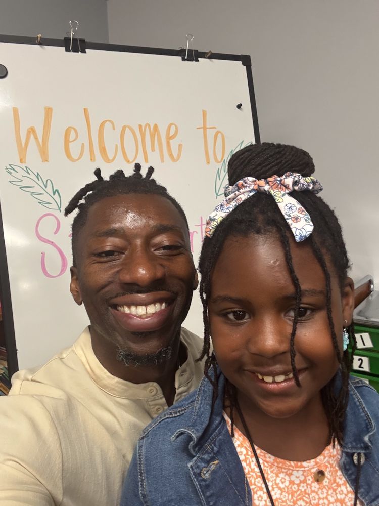 A man and a girl are posing for a picture in front of a whiteboard that says welcome to science