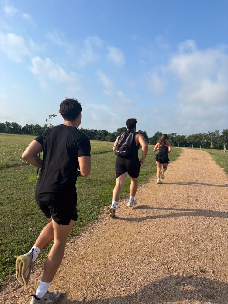 A group of people are running down a dirt path.