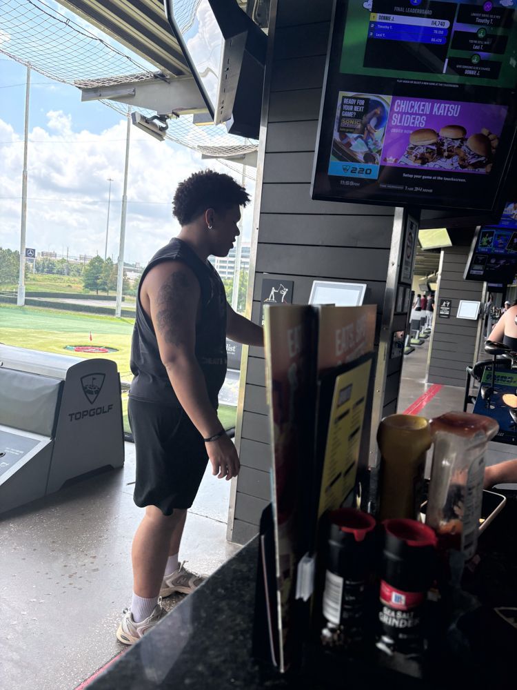 A man is standing at a bar in a restaurant.