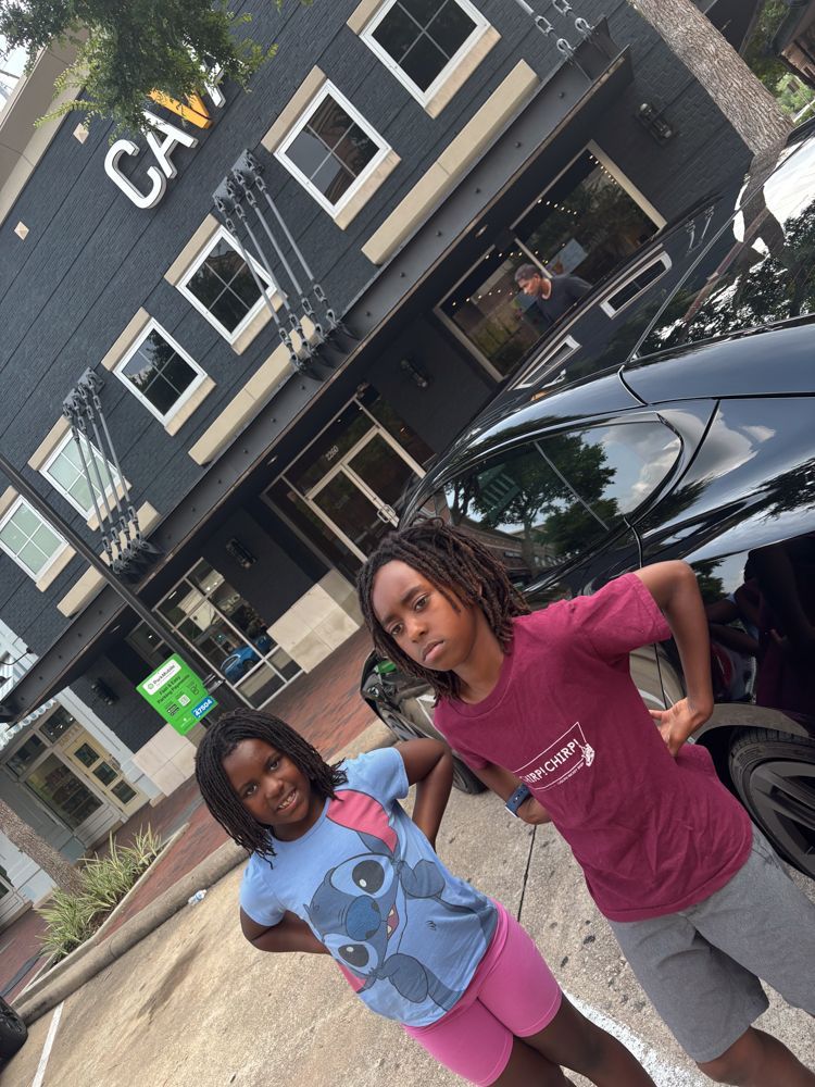 Two girls standing in front of a building that says cave