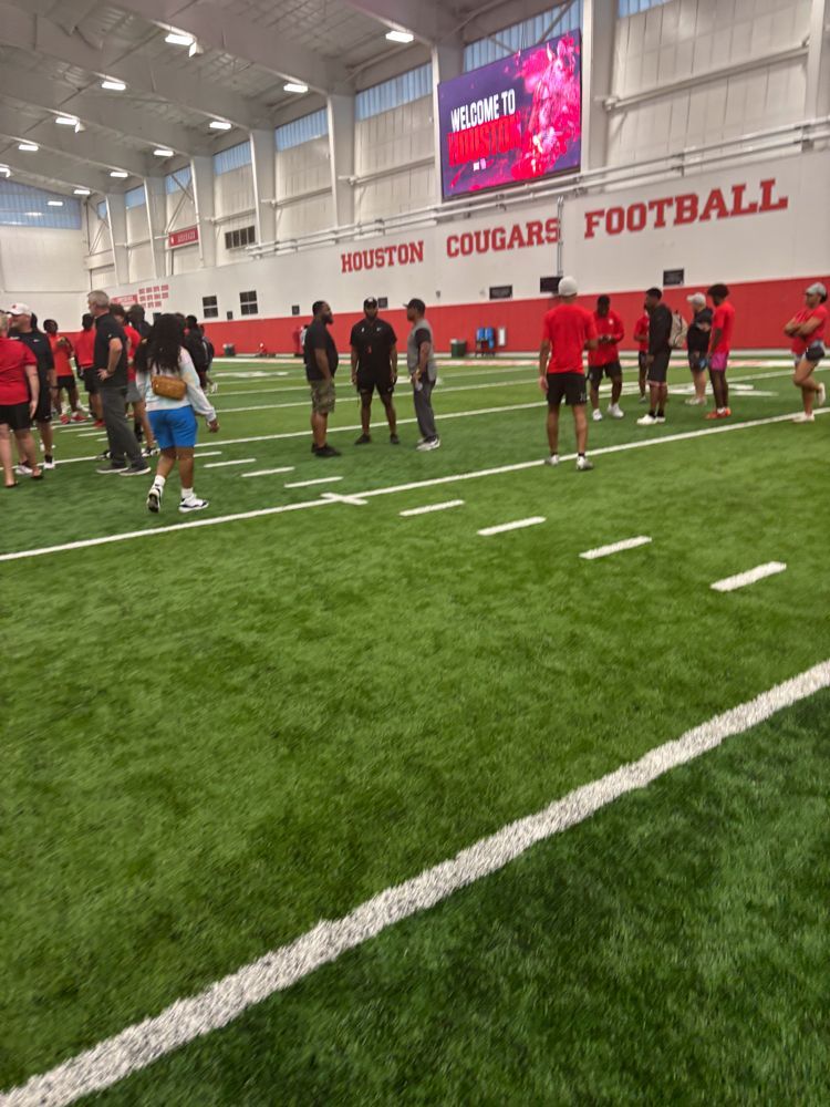 A group of people are standing on a football field.