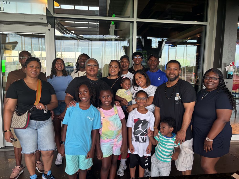 A large group of people are posing for a picture in front of a building.