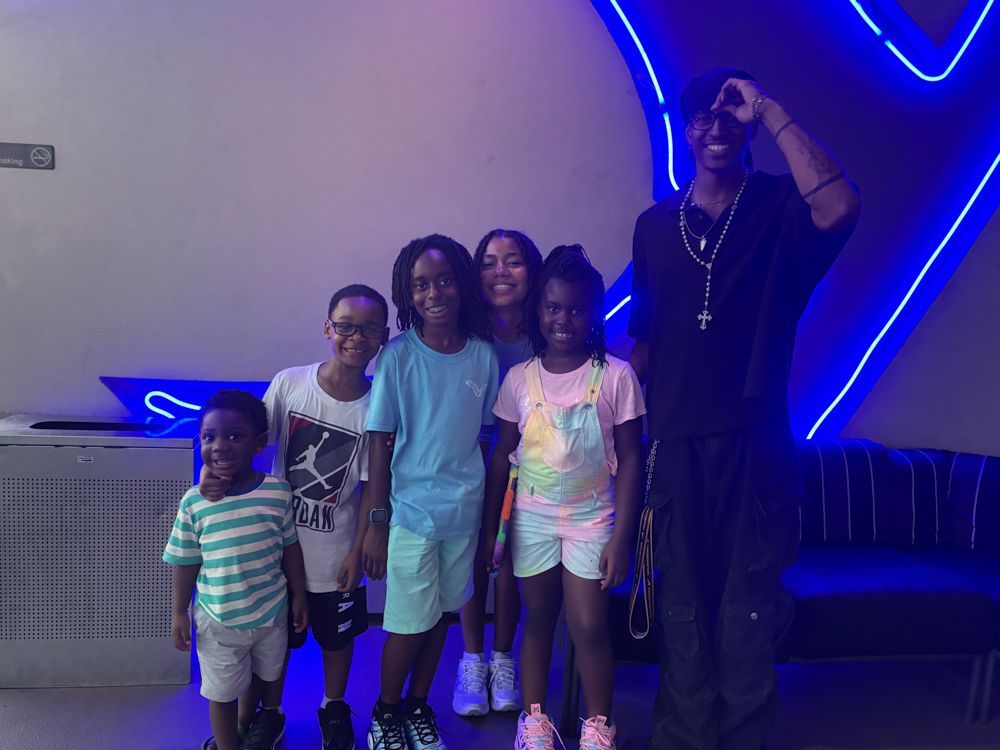 A group of children and a man are posing for a picture.