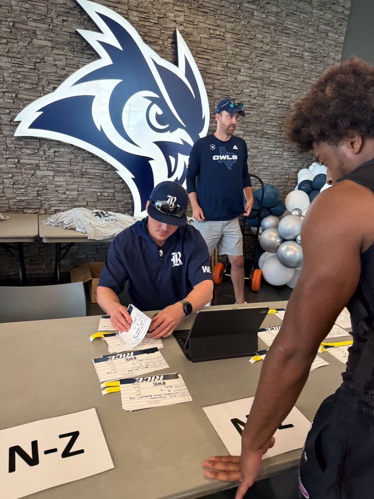 A man sitting at a table with a laptop and a sign that says n-z