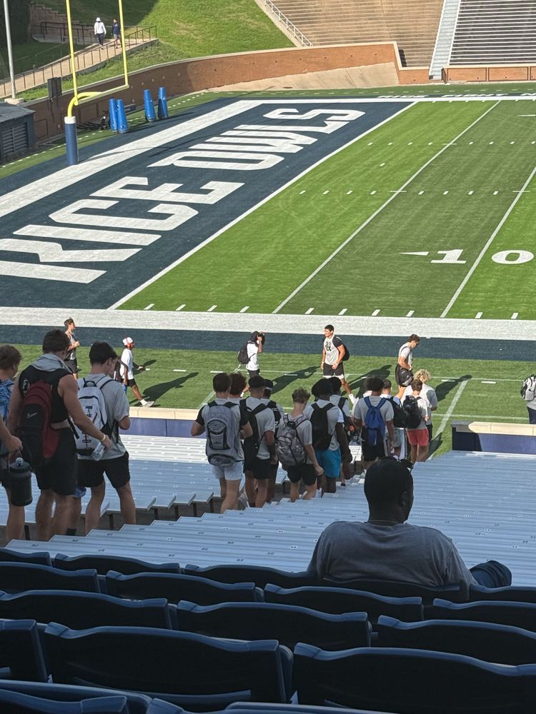 A group of people standing on the bleachers of a football stadium