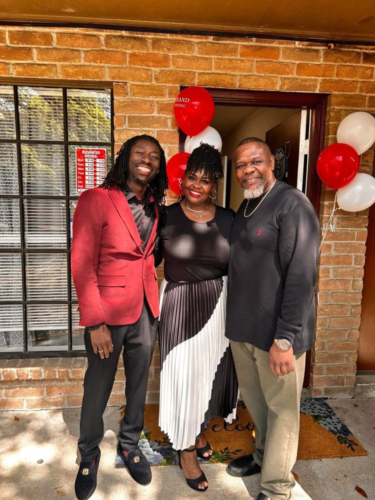 A group of people are posing for a picture in front of a brick building.