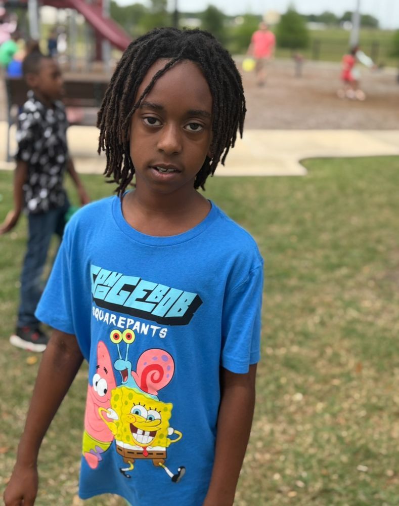A young boy wearing a blue shirt with spongebob and patrick on it
