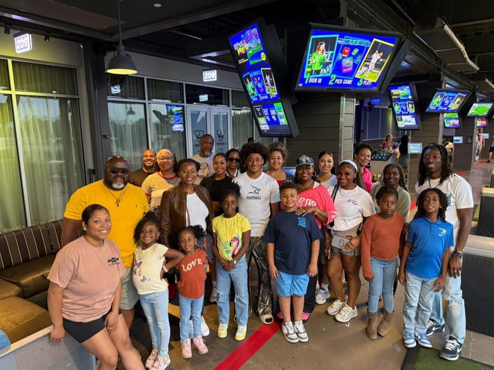 A large group of people are posing for a picture in a bowling alley.