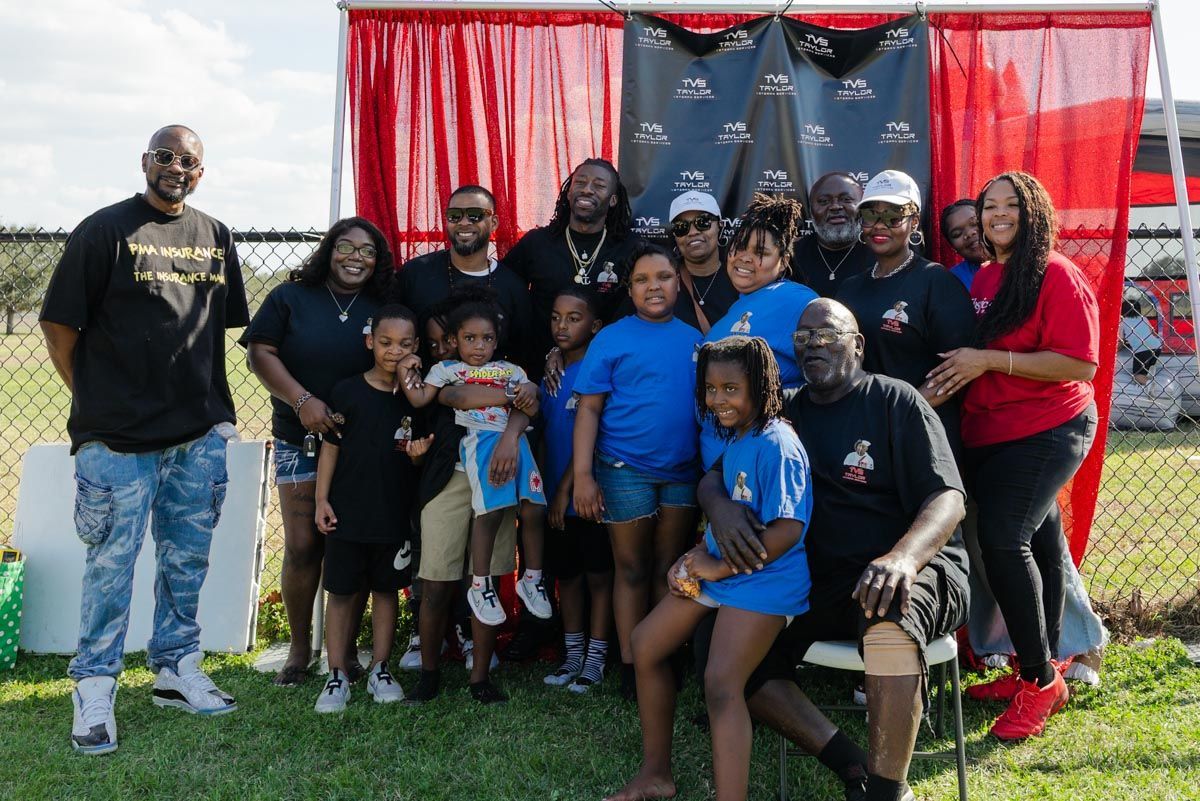 A large group of people are posing for a picture in a field.