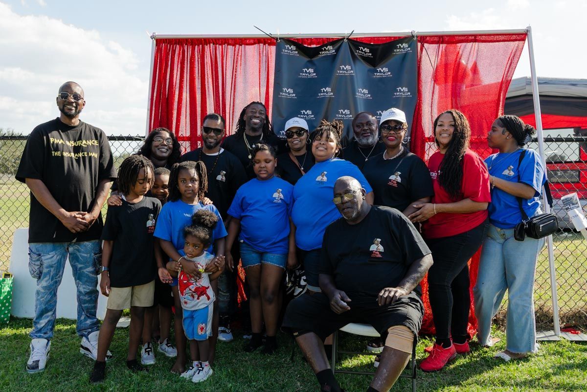 A group of people are posing for a picture in front of a red curtain.