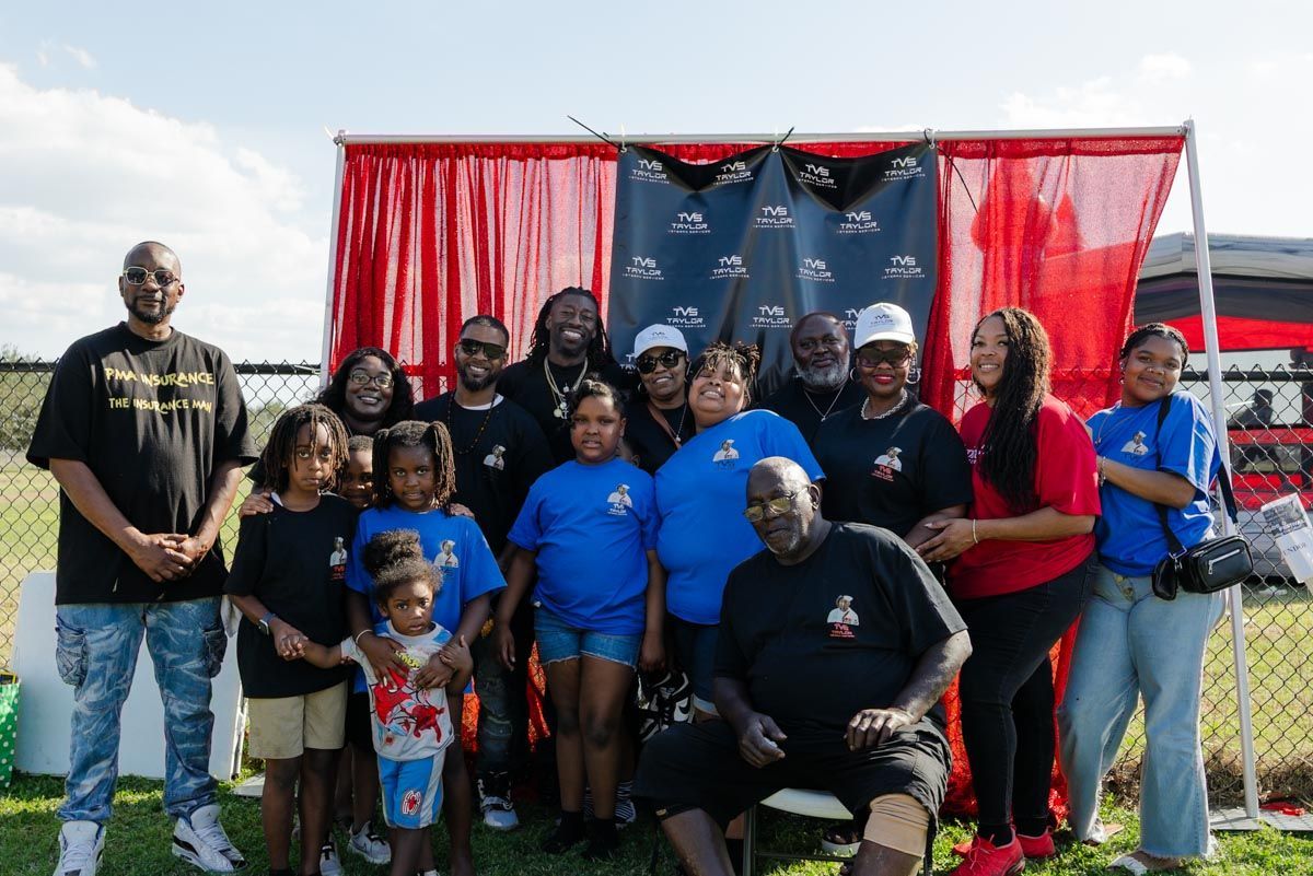 A group of people are posing for a picture in front of a red curtain.