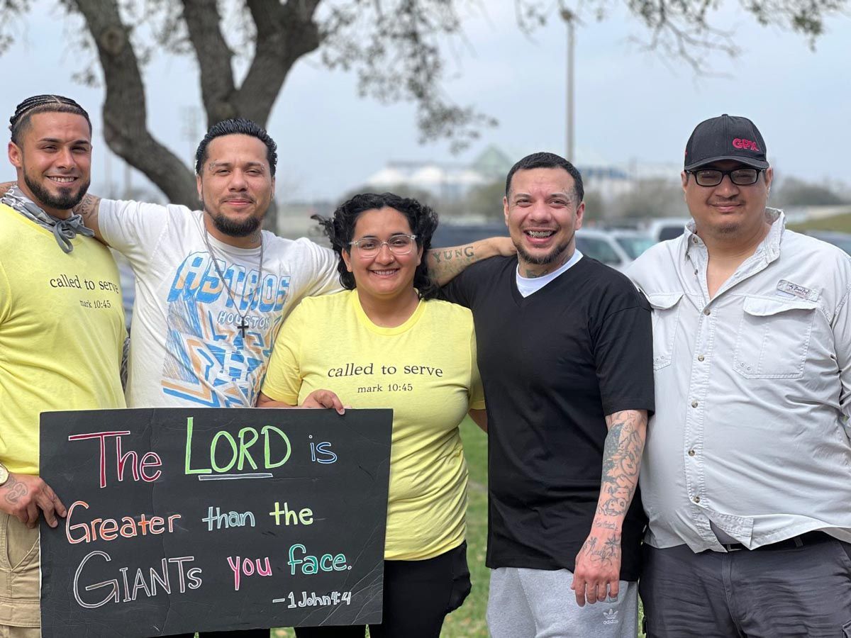 A group of people holding a sign that says the lord is greater than the giants you face