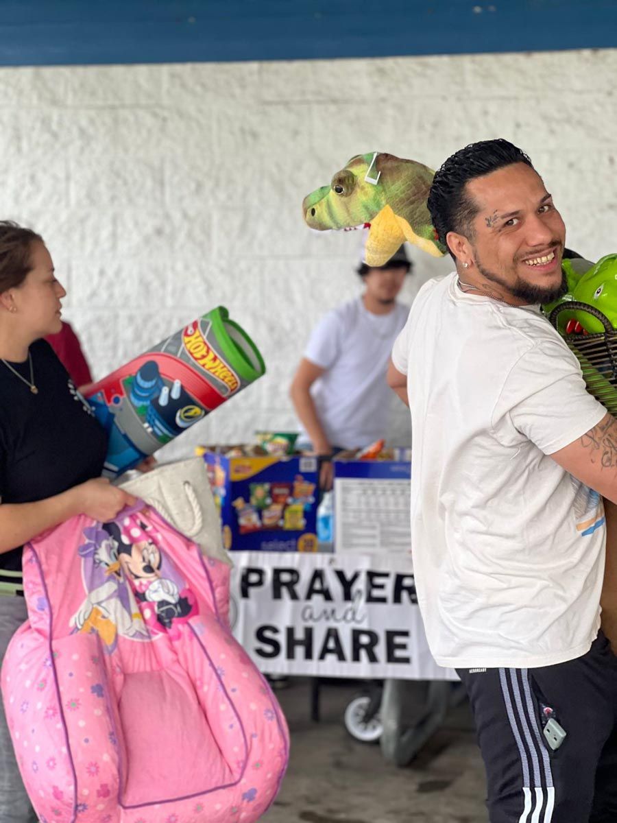 A group of people are standing in front of a sign that says prayer and share