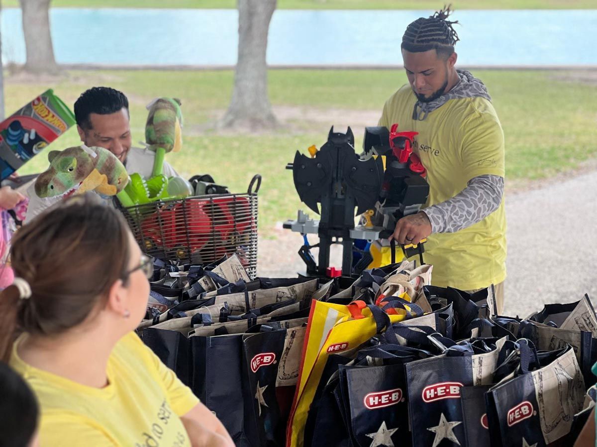 A man is standing in front of a table full of shopping bags.
