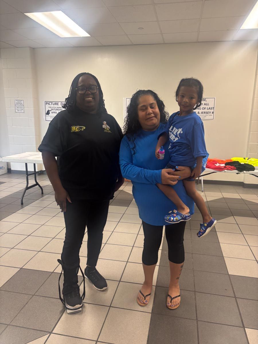 A woman in a blue shirt is holding a child