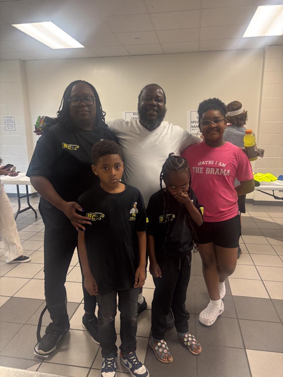 A group of people posing for a picture with one girl wearing a pink shirt that says the dream