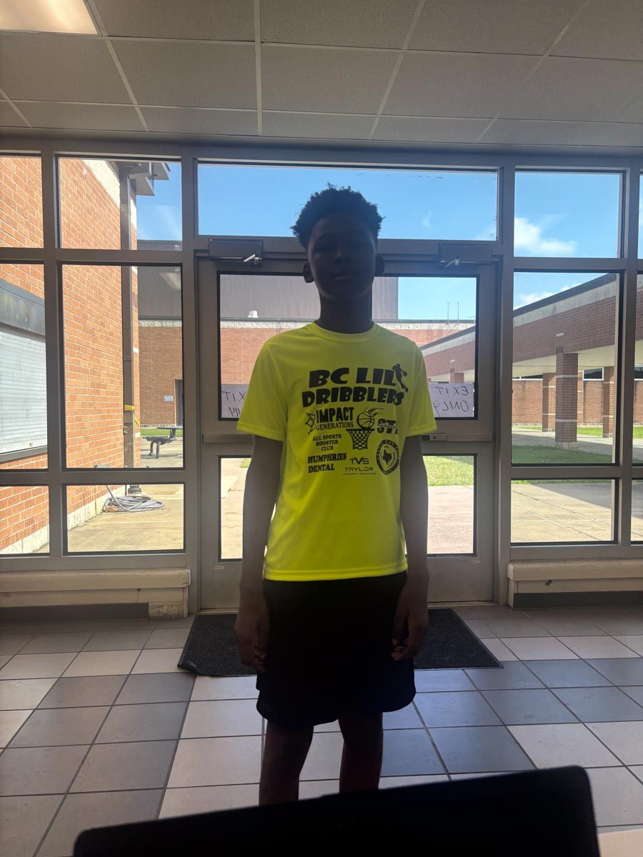 A boy wearing a yellow shirt that says dc life supplies