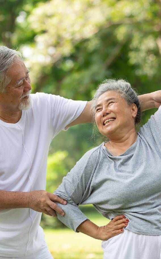 Senior Couple Stretching Before Exercise and Doing Yoga