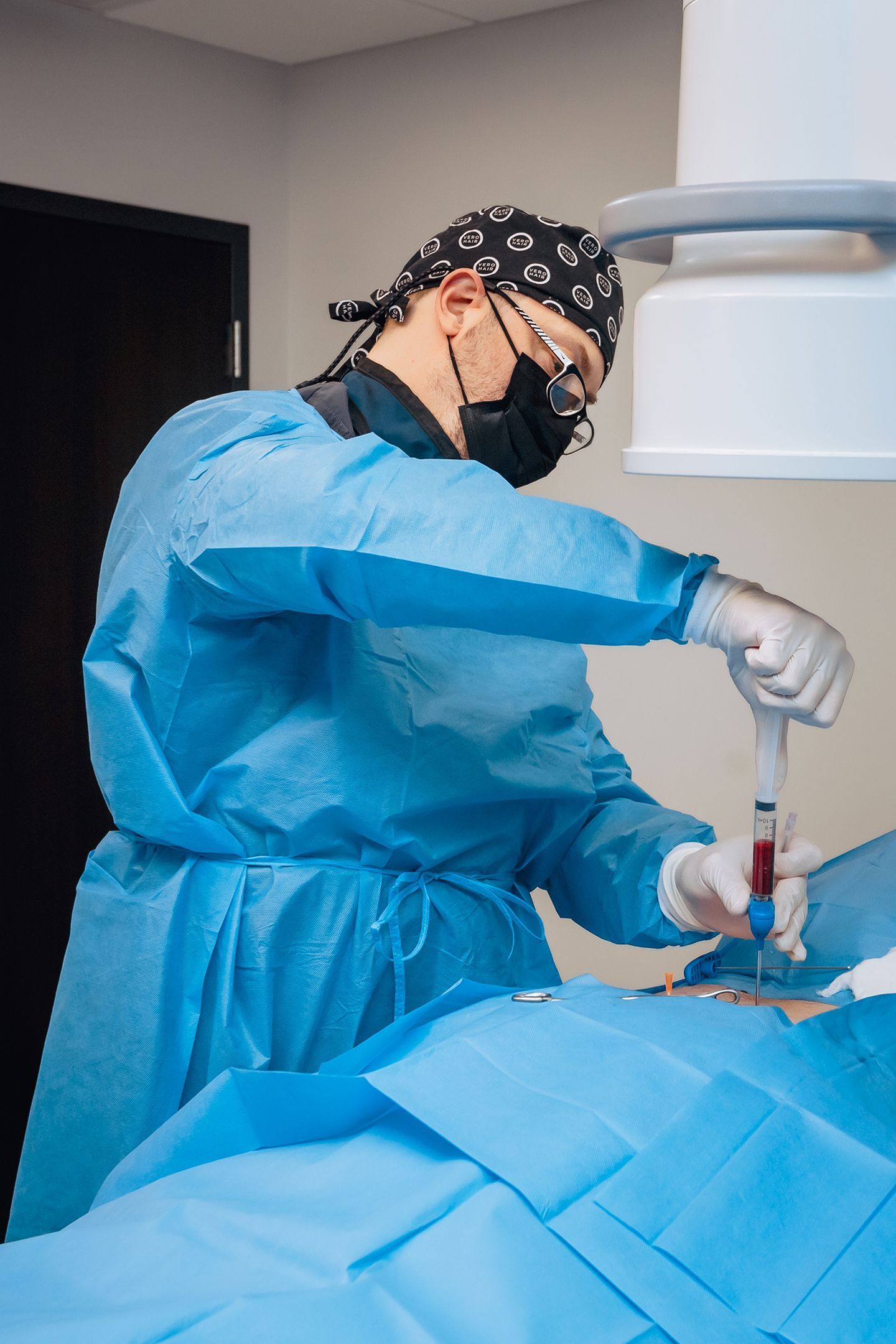 A surgeon is operating on a patient in an operating room.