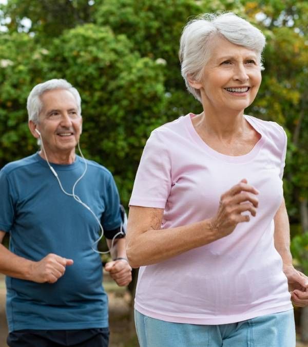 Senior Couple Running Outside at Park