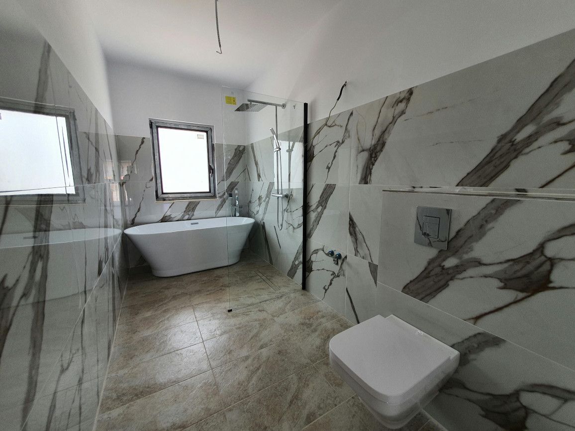 Lovely modern bathroom with stylish tiling completed in Swansea by Daffodil Tiling.