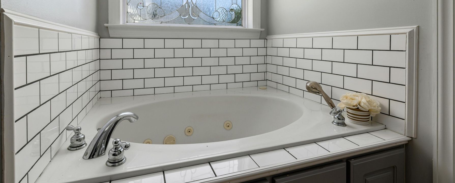 Close-up of a neatly tiled bathroom sink backsplash in Swansea.