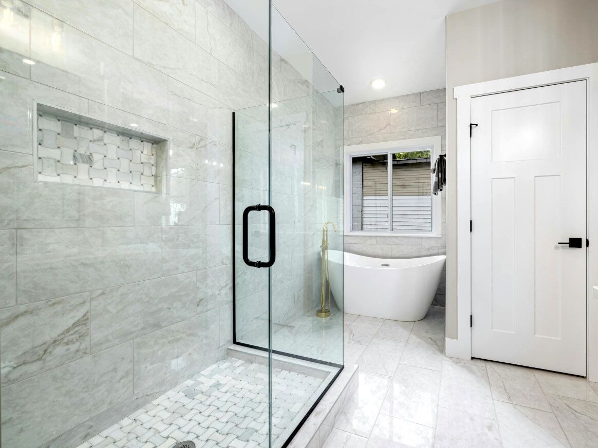 Swansea bathroom with marble large format floor, shower and wall tiles, professionally installed by Daffodil Tiling.