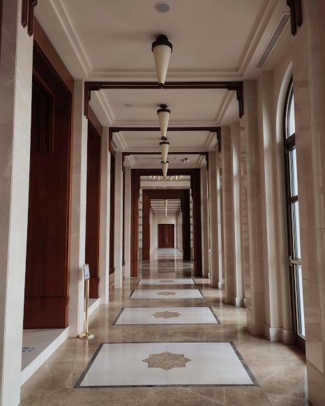 A long hallway with a few lamps hanging from the ceiling