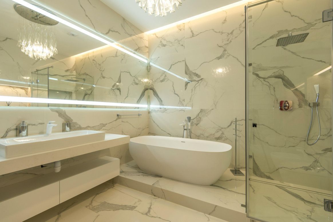 Luxurious marble bathroom with a freestanding tub, sink, and shower.