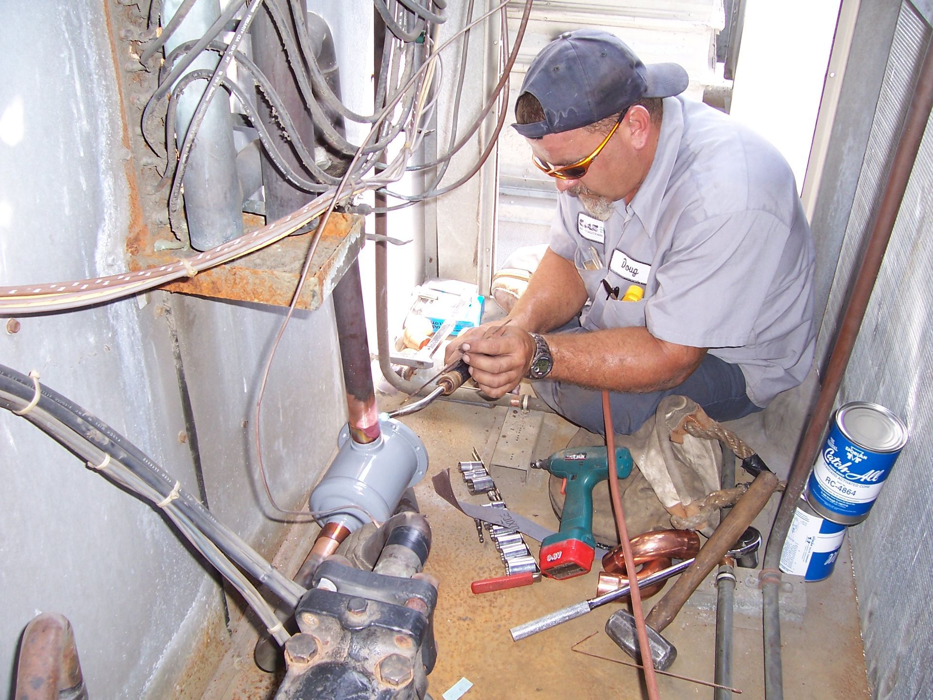 A man in a gray shirt is working on a machine