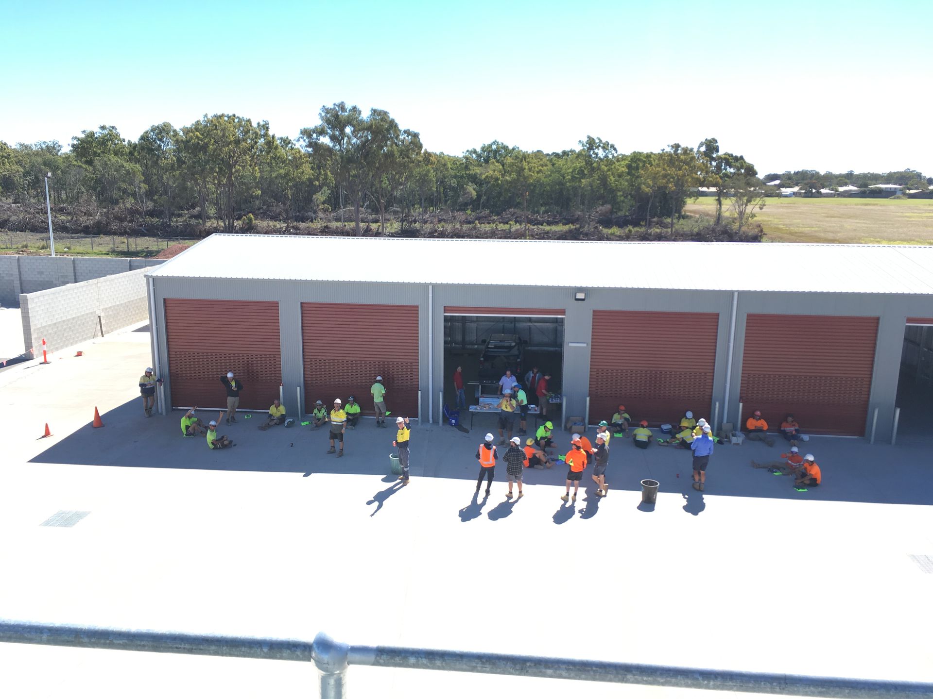 A group of people are standing outside of a building.   — Showcase Concrete & Polishing in Bundaberg South, QLD