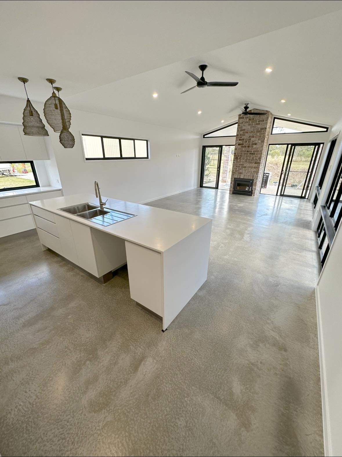 A kitchen with a large island and a ceiling fan.   — Showcase Concrete & Polishing in Bundaberg South, QLD