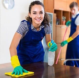 Woman Smiles While Wiping a Table — Janitorial Service in Atlanta, GA