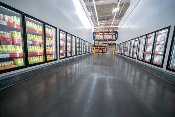 Grocery store aisle with refrigerated display cases, polished floor, bright lighting.